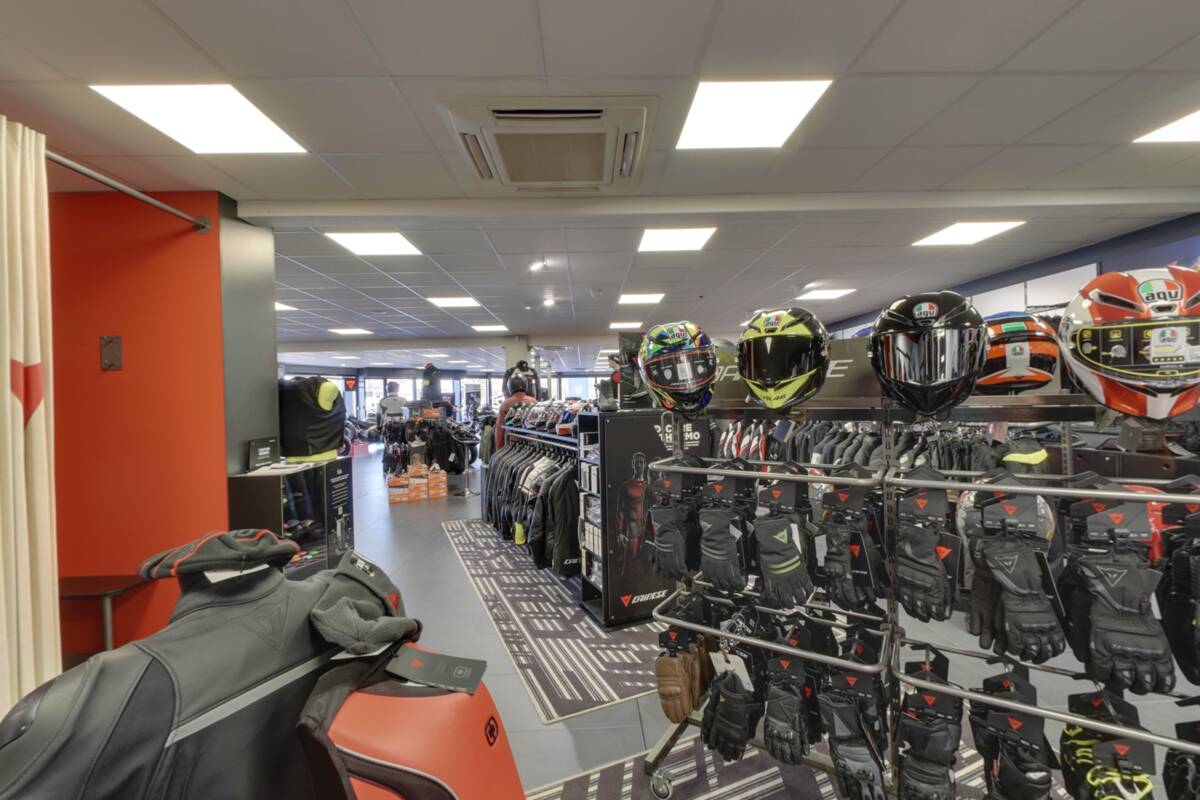 Motorcycle gloves and helmets on the shelves at Profil Motos near Annemasse